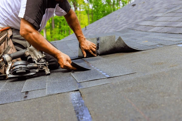 Artisan réparant l'étanchéité d'une couverture avec des outils spécialisés